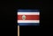 The national flag of the republic Costa Rica on toothpick and on black background. Located in central america.