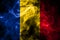 National flag of Romania made from colored smoke isolated on black background. Abstract silky wave background.