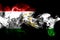 National flag of Tajikistan made from colored smoke on black background. Abstract silky wave background.