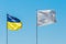 National flag of Ukraine, a symbol of patriotism and the nation of Ukraine against the blue sky opposite the white flag sign and