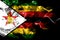 National flag of Zimbabwe made from colored smoke isolated on black background. Abstract silky wave background