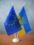 National flags Ukraine and flag of European Union on table and hands of heads of governments, help the Ukraine