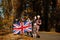 National holiday of United Kingdom. Family with british flags in autumn park.  Britishness celebrating UK. Mother with four kids