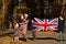 National holiday of United Kingdom. Family with british flags in autumn park.  Britishness celebrating UK. Mother with four kids