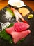 National Japanese food: black plate, on it sashimi from raw tuna, shrimps, scallops with finely chopped daikon.