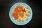 National Kushari in a turquoise plate on dark wooden background