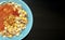 National Kushari in a turquoise plate on dark wooden background with copy space