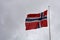 National norwegian flag is blowing in the wind in front of dark