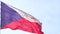 The national state flag of the Czech Republic waving in the wind on a flagpole against the blue sky