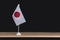 National Table flag of Japan on black background. Space for text