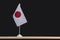 National Table flag of Japan on black background. White flag with red circle