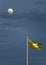 A National Trust flag flies high on a Cornish rooftop,with the silver moon shining beyond .against a darkening sky