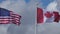 The national USA and canadian flags waving in the wind.