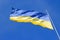 The national yellow-blue flag of Ukraine waving on the wind, against clear blue sky. Ukrainian symbol
