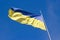 The national yellow-blue flag of Ukraine waving on the wind, against clear blue sky. Ukrainian symbol