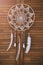 Native american indian magical dreamcatcher with sacred feathers. amulet on wooden background. Shaman