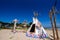 Native american indian tepee and totem pole on the beach blue sk