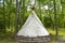 Native American wigwam made of fabric covered branches in forest