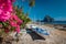 Native banca boat and vibrant flowers at Las cabanas beach with amazing Pinagbuyutan island in background. Exotic nature