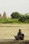 A native Burmese woman is carrying a baby asking for money from a tourist who visits an ancient pagoda in Bagan, Myanmar.