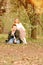 Native cheerful elder brother and little sister have fun in spring park where blossoming cherry flowers in a botanical garden