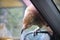 Native New Zealand Kea bird sitting on car mirror and trying to break inside with sharp beak, Arthurs Pass Village