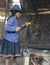 Native Peruvian woman preparing guinea pigs over fire