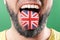 Native speaker. The protruding tongue of a bearded man is close-up, in the colors of the English flag. The concept of