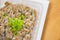 Natto - a popular and healthy Japanese food from fermented beans in a Styrofoam container with green spring onions as toppings.