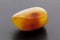 Natural amber. A piece of yellow opaque natural amber on dark grey background.