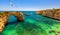 Natural arch above ocean, Arco de Albandeira, Algarve, Portugal. Stone arch at Praia de Albandeira, Lagoa, Algarve, Portugal. View