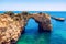 Natural arch above ocean, Arco de Albandeira, Algarve, Portugal. Stone arch at Praia de Albandeira, Lagoa, Algarve, Portugal. View