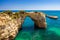 Natural arch above ocean, Arco de Albandeira, Algarve, Portugal. Stone arch at Praia de Albandeira, Lagoa, Algarve, Portugal. View