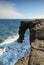 Natural arch in the black lava rock cliffs