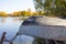 Natural autumn landscape with inverted boat on lakes shore. Fishing concept. Rusty ancient boat at old pier