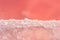 Natural background with pink salt lake. A clear line of pink water and salt. Salt used in medicine, dermatology and spa