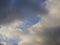 Natural background of white clouds and gray thunderclouds with gleams of blue sky.