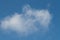 Natural background. White fluffy cloud on a background of blue sky