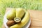 Natural banana, kiwi fruit and pears on wooden table and on green grasses background in nature . Top view with copy space. Rustic