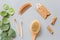 Natural bathroom accessories: wooden comb, bamboo toothbrush, massage brush, ear sticks on gray paper background. Zero waste