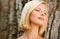 Natural beauty up close. Relaxed young woman leaning against a tree trunk.