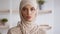Natural beauty. Young serious muslim woman wearing traditional headscarf looking at camera, posing at home