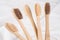 Natural biodegradable eco-friendly wooden toothbrushes with BPA free bristles against white wall