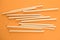 Natural biodegradable wheat drinking straws made of the stem of the wheat plant on orange background