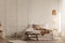 Natural blanket on white bed in simple bedroom interior with fur next to wooden stool