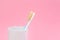 Natural bristle toothbrush in holder on pink. Space for text