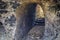 Natural cave in rock. Sea cavern on the coast. Tropical nature. Cave with steps and narrow entrance. Travel in wild Africa.