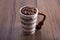 Natural coffee beans in an artistic musical cup. Music notes painted on the cup with a cello shaped handle. International Coffee