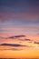 Natural color dramatic dawn or dusk sky with painterly yellow, pink and blue clouds with horizon, taken with telephoto 135 mm