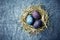 Natural colored Easter eggs in a hay nest. Flat lay. Copy space